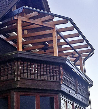 Komplett aus dunkel gestrichenem Holz gefertigter Balkon